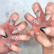 Two hands with hand painted salon press-on nails in long almond shape, featuring black and silver polka dots, bows, and french tips on neutral background